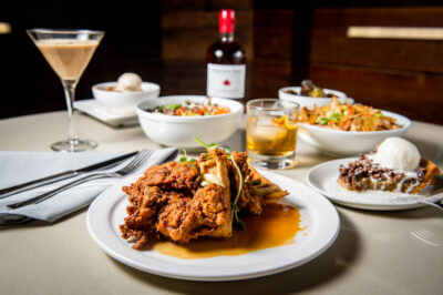Maple-inspired menu items and beverages with a bottle of maple syrup on a white table