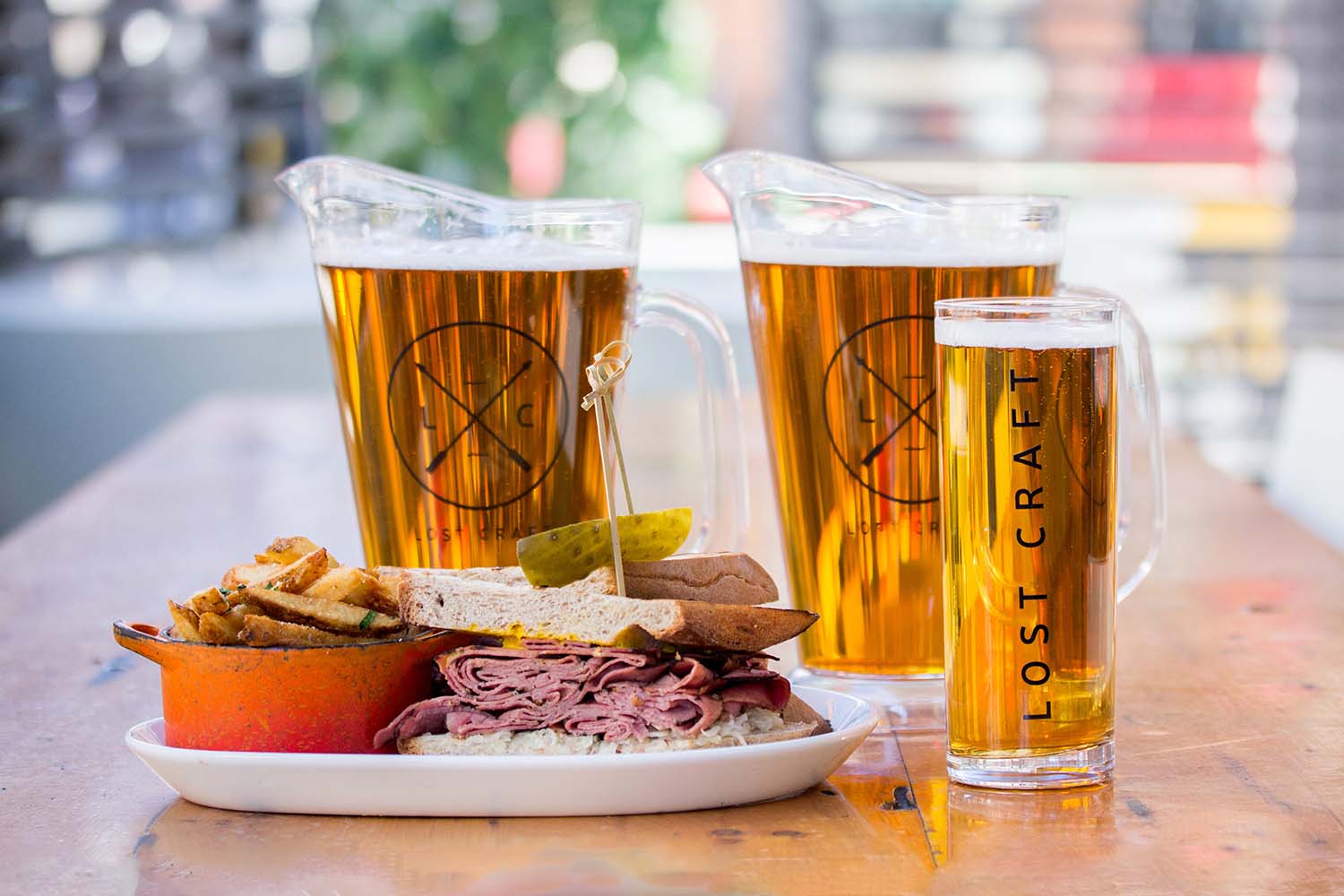 Two pitchers and a beer next to a dish on the patio