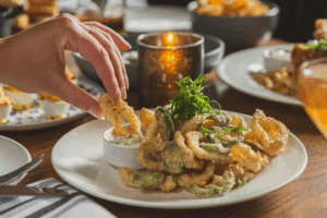 Hand dipping Crispy Calamari in tartar sauce