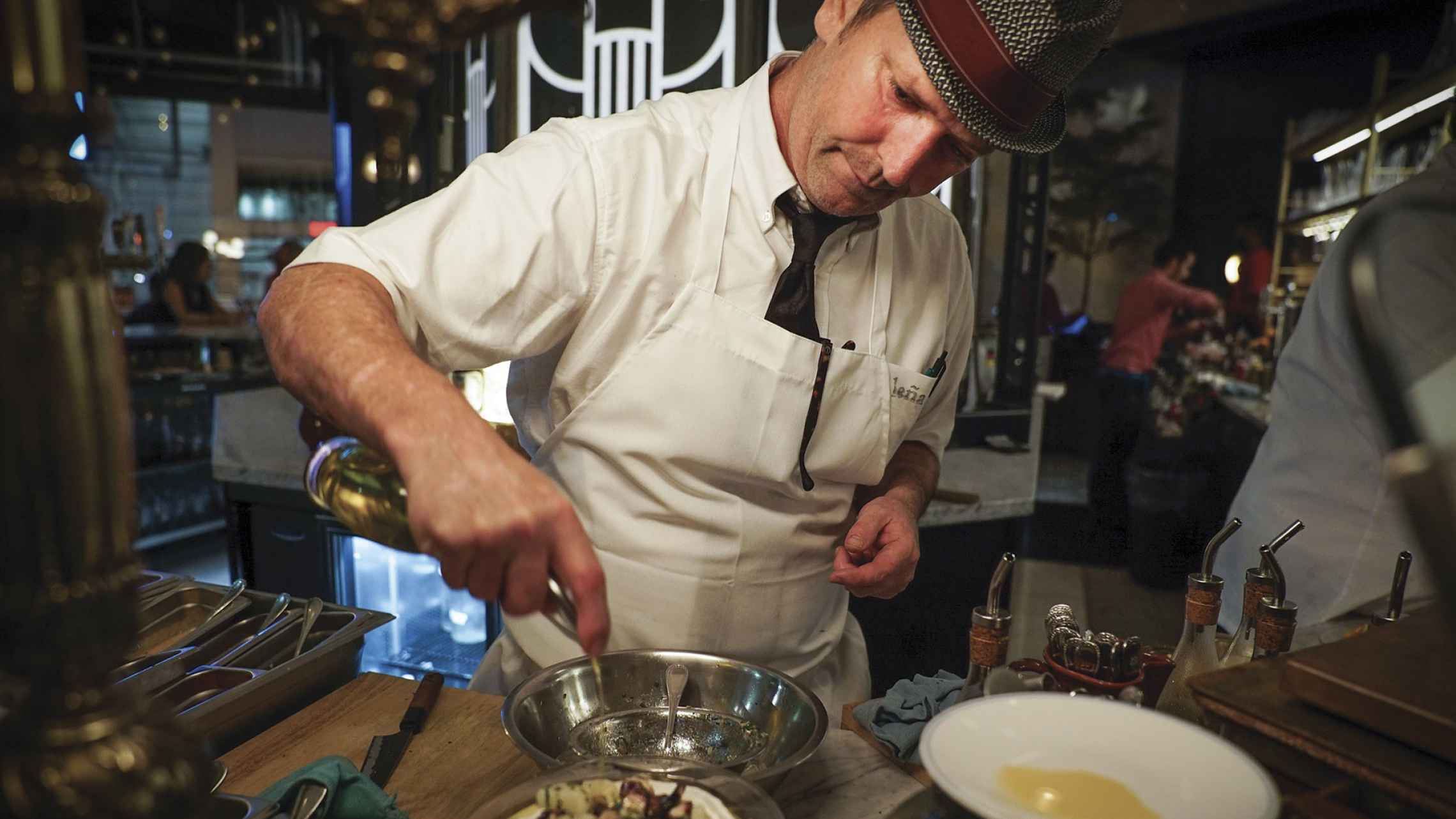 Chef Anthony Walsh preparing a dish at the Lena bar