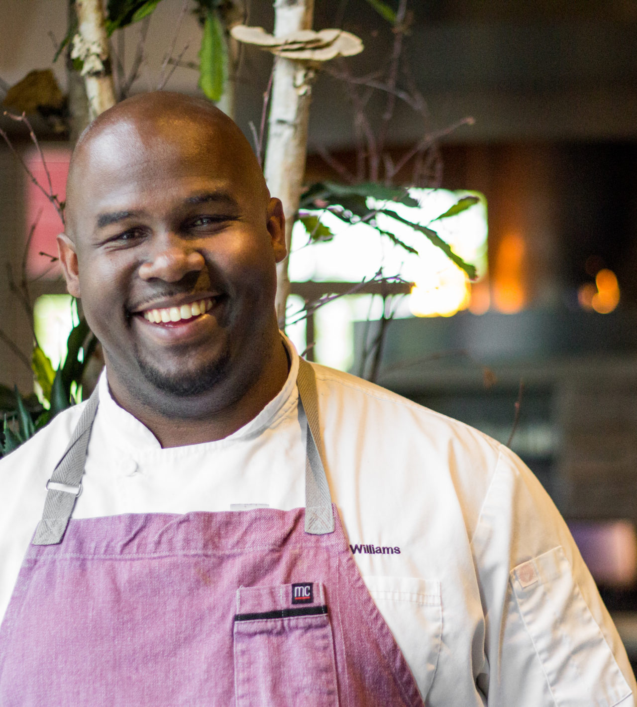 Chef Gerry Williams wearing a white jacket and purple apron