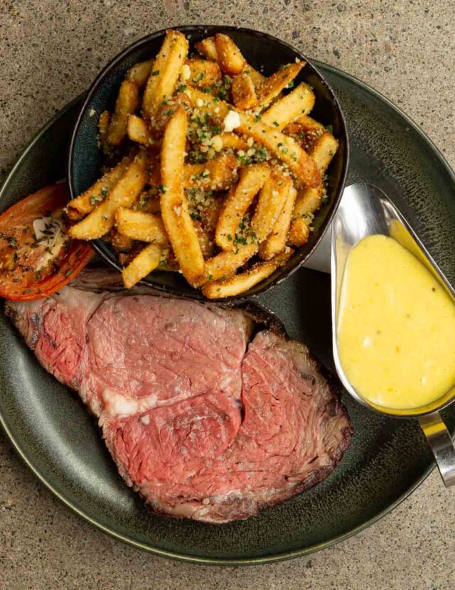 plate of prime rib, truffle Parmesan fries, green beans, roasted tomato, beer-naise sauce