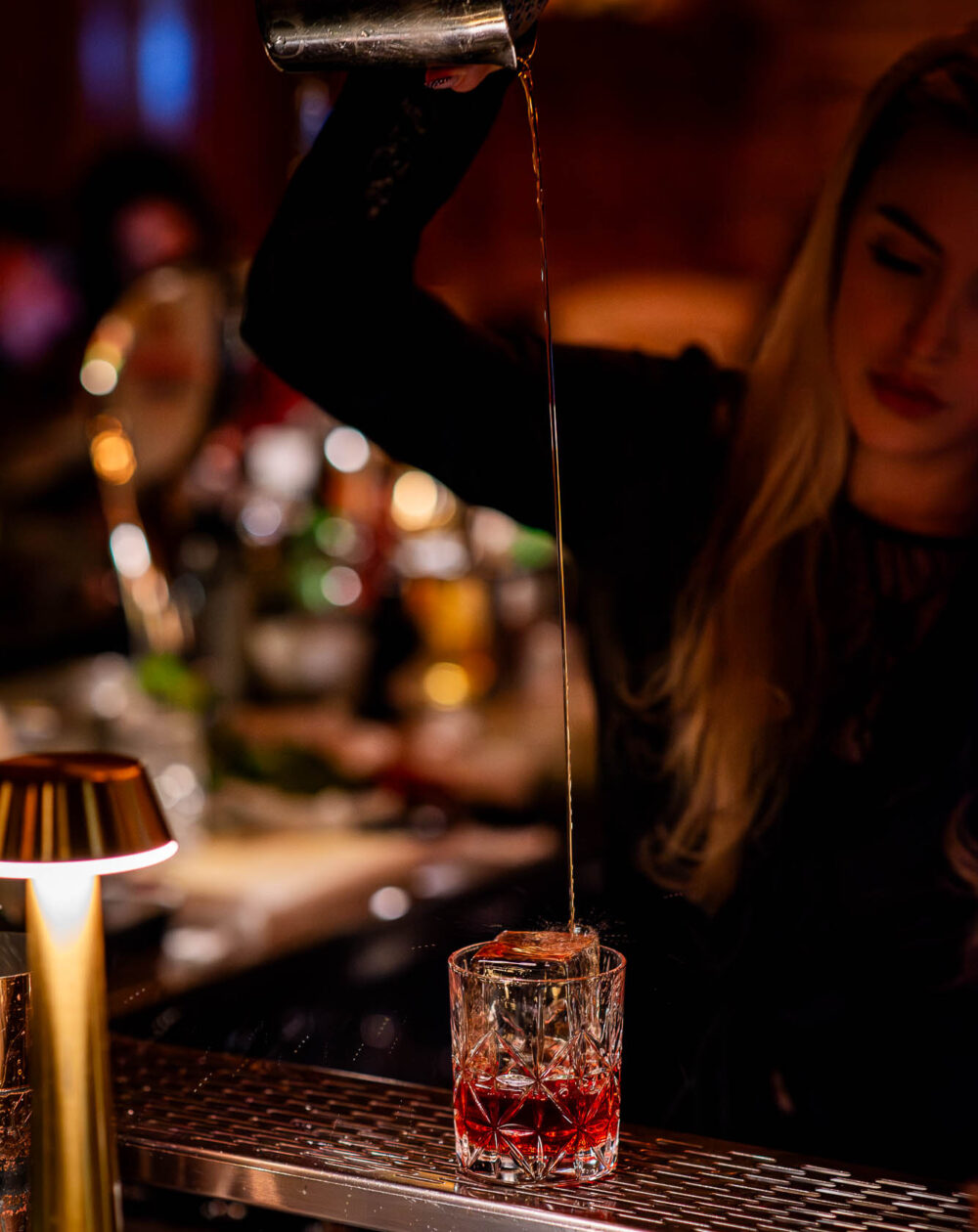 bartender long pours a drink