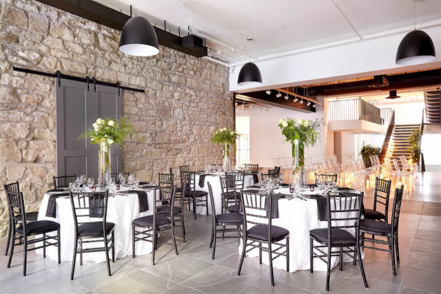 Seated event with black chairs and white table cloths at The Pioneer in Calgary