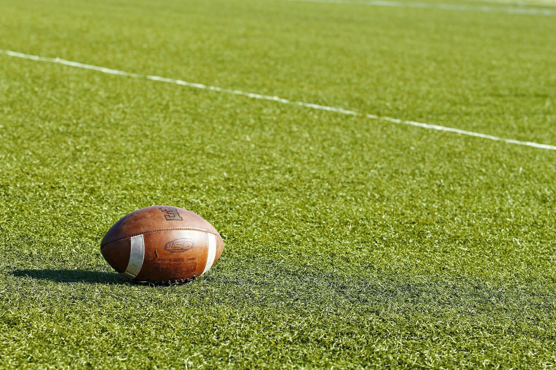 American football sitting on a football field