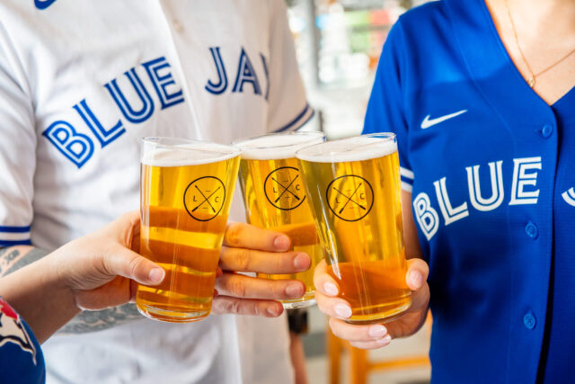 Guests wearing Blue Jays jerseys drinking Lost Craft beer