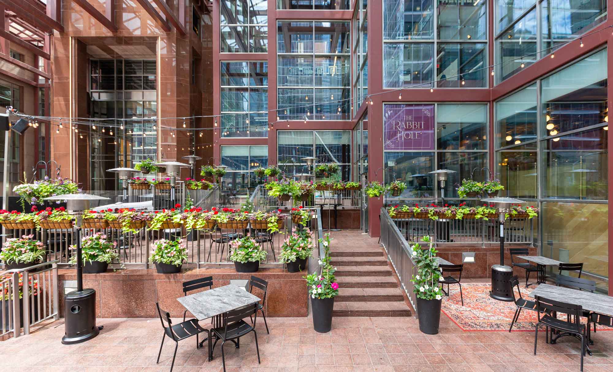 A multi-level patio with tons of flower pots outside The Rabbit Hole.