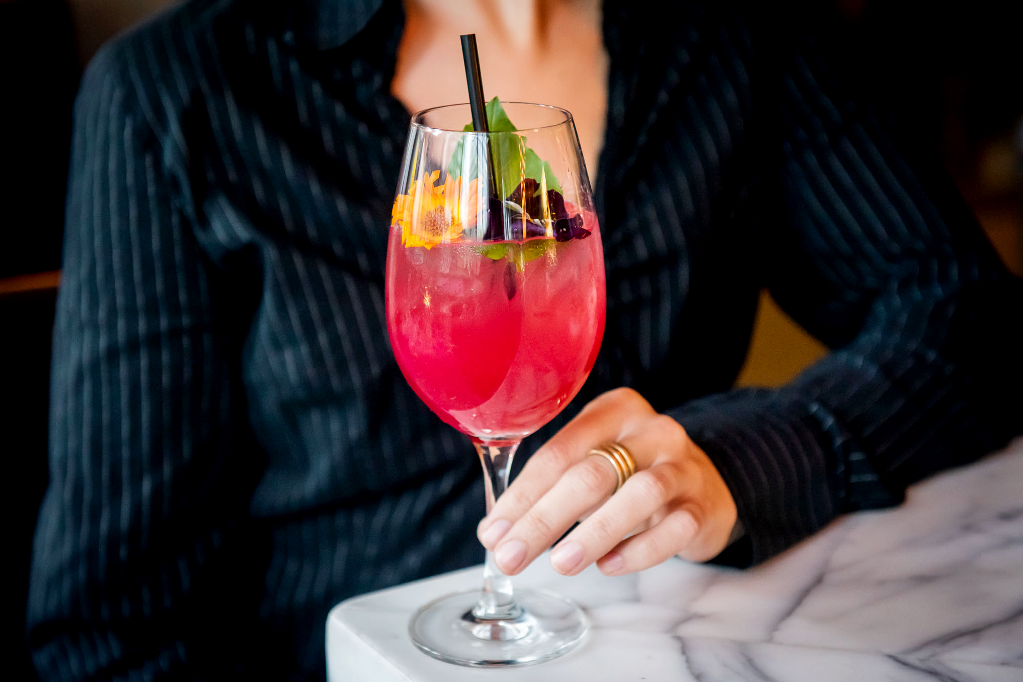 Person holding a pink cocktail at the Luma bar