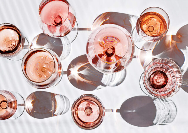 Flatlay of glasses of rosé on a white table