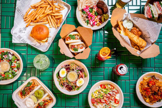 top down of many take out food dishes on tiled green table