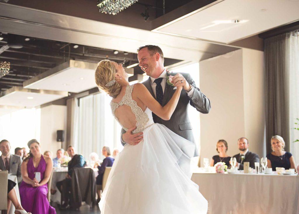 A bride and groom sharing a first dance and smiling at one another at Arcadian Loft