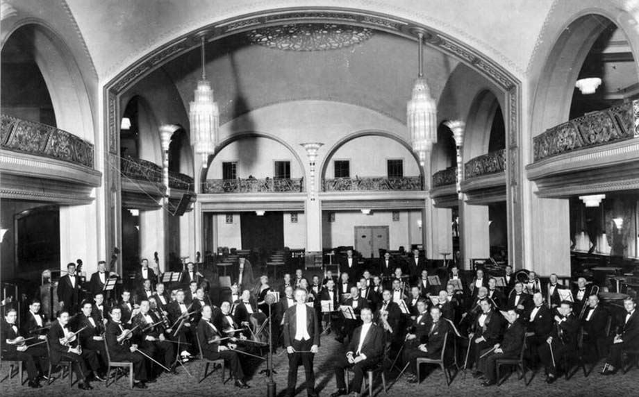 vintage photo of composer and musicians at arcadian court event venue looking at camera