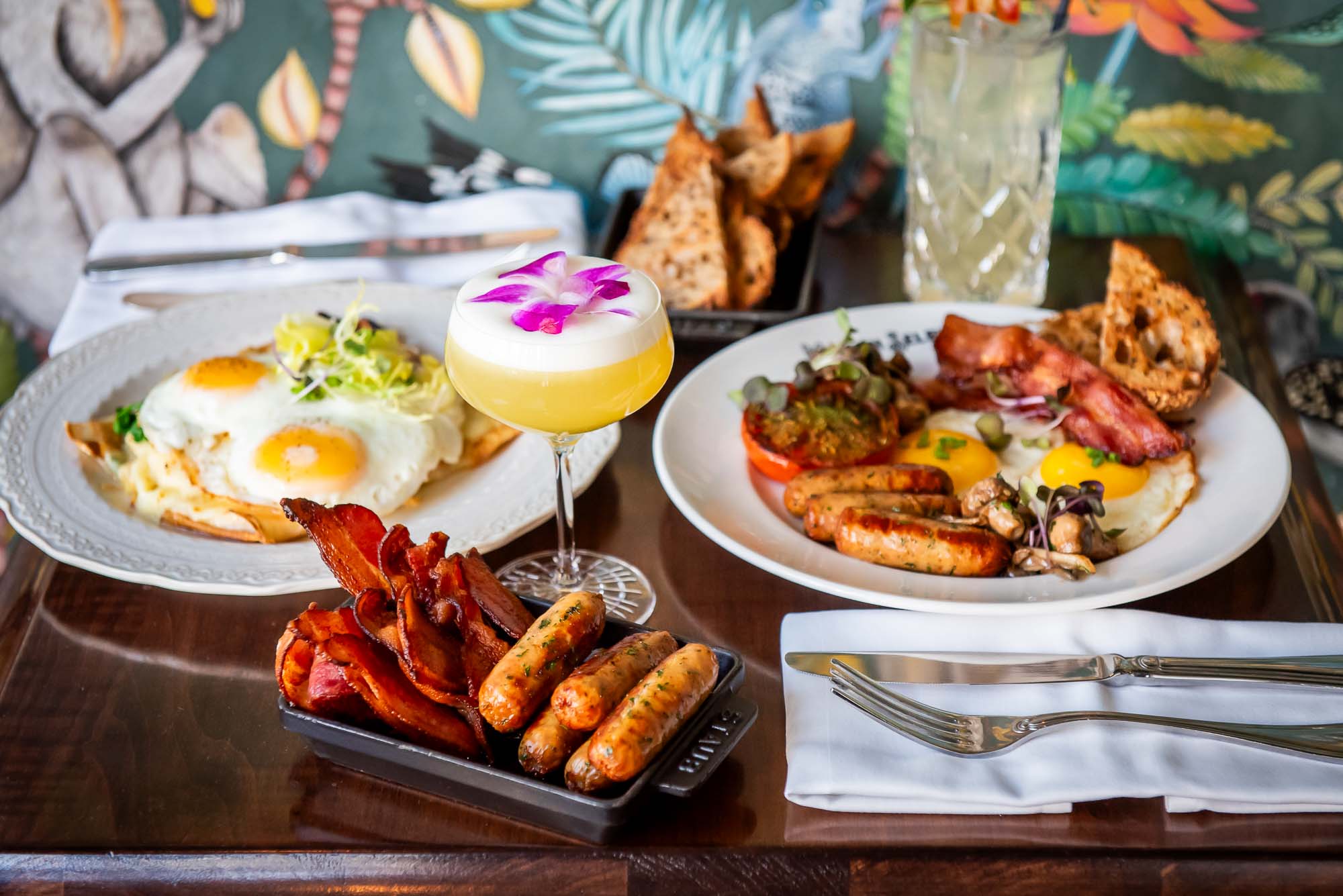 Eggs Hemingway, The Full Selby, and cocktails on a wood top table