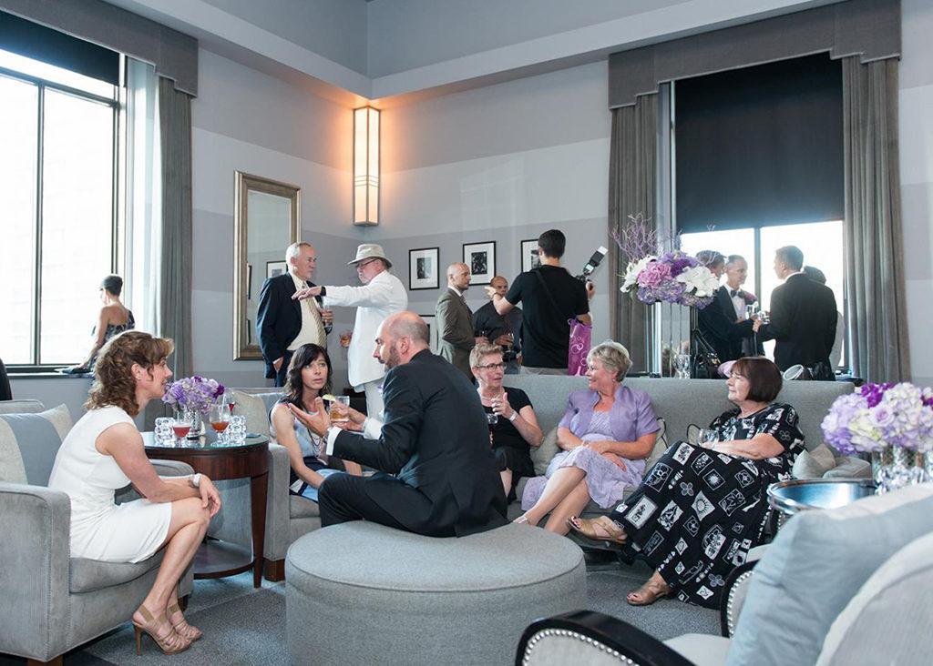 People conversing and mingling in the Clipper Room event space at The Carlu in Toronto