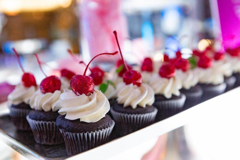 Chocolate cupcakes topped with glittery cherries at The Carlu