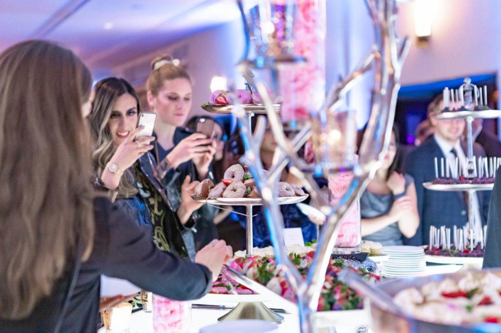 Guests taking photos of a dessert station at The Carly