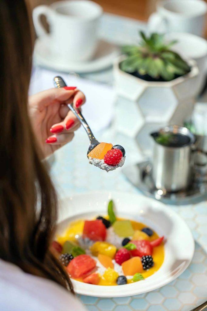 lady scooping from the fruit bowl using a spoon