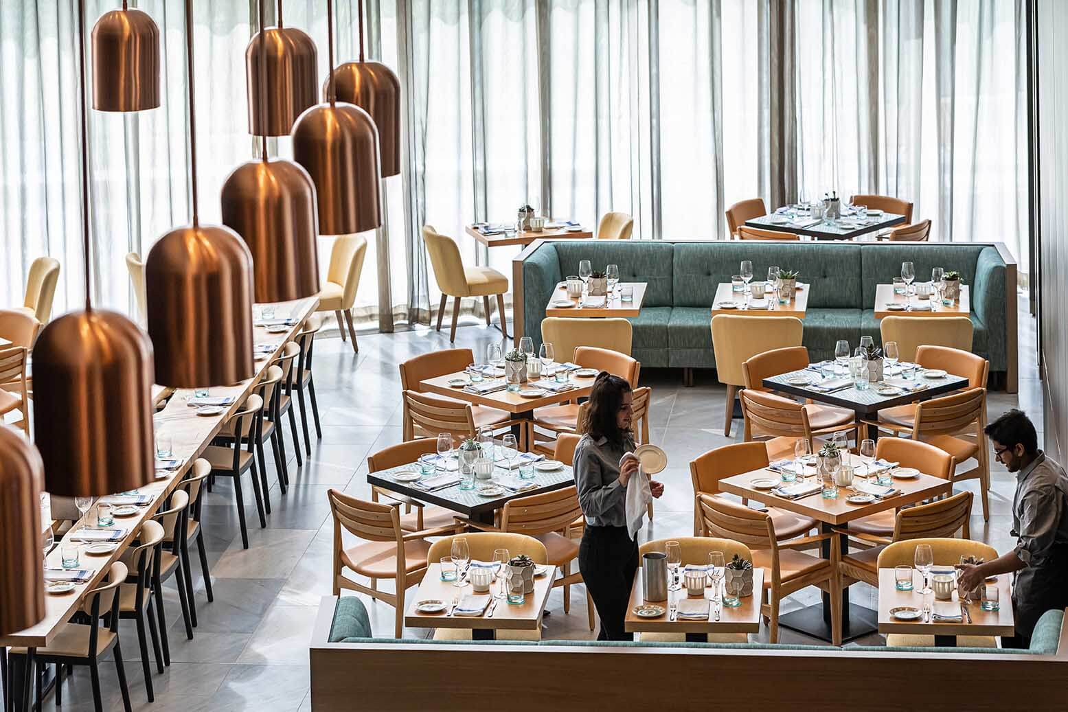 Overlooking the interior of the restaurant with a server setting up tables