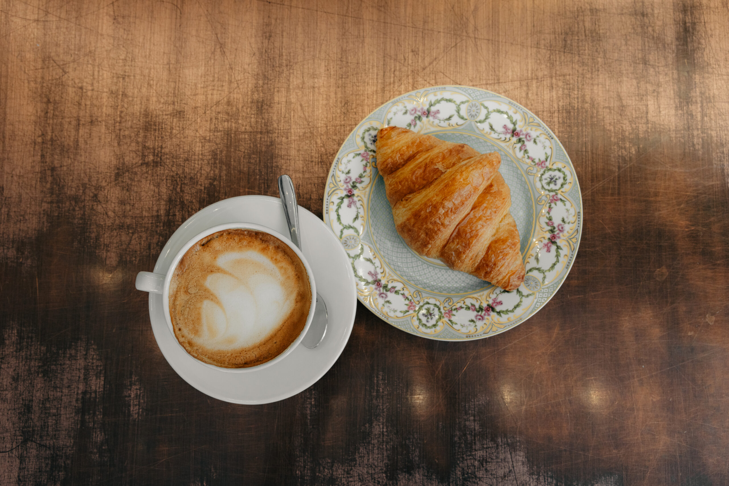Coffee and croissant in a wood table
