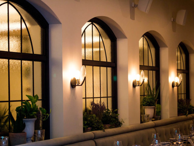 arched windows and wall sconces in the dining room at Babel