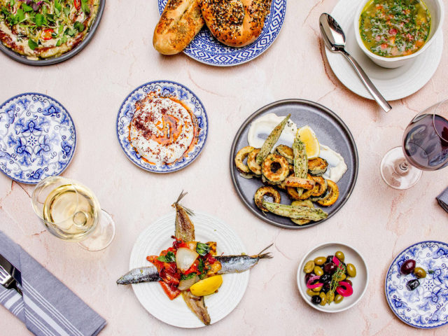 Flatlay of Babel bread, charred eggplant, olives, soup and seafood at Babel restaurant